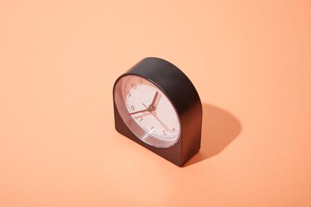 black clock on peach background with copy space