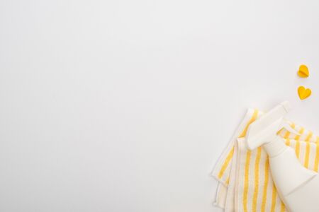 top view of yellow cleaning supplies and hearts on white backgroundの写真素材