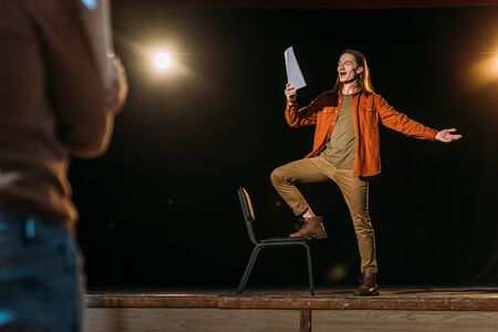 handsome young actor with scenario rehearsing with theater directorの写真素材