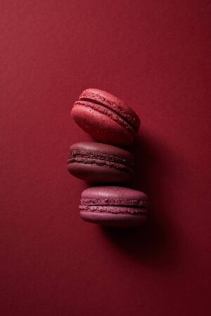 top view of delicious colorful french macaroons on red backgroundの写真素材