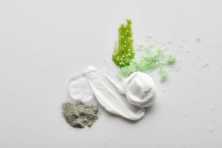 Top view of cosmetic cream brushstrokes, gel, clay powder, sea salt and scrub on grey backgroundの写真素材