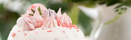 close up view of delicious Easter cake with white glaze and meringue, panoramic shot