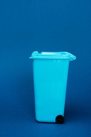 toy trash can on blue background with copy spaceの写真素材