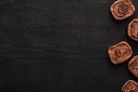 Top view of shamanic clay amulets with symbols on dark wooden surface