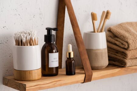 Selective focus of hygiene and cosmetic products with towels on shelf in bathroom, zero waste conceptの写真素材