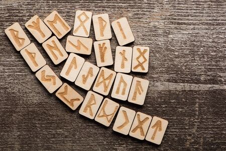 Top view of ethnic runes on wooden surface with copy space