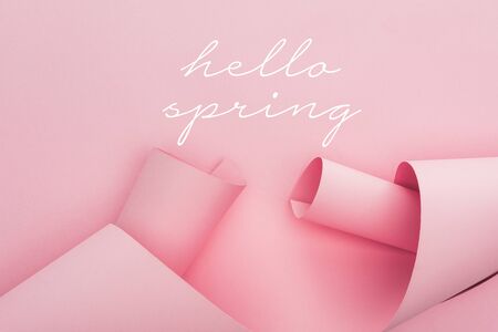 top view of pink paper swirls on pink background, hello spring illustrationの写真素材