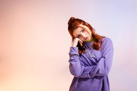 beautiful bored redhead teen girl, on purple and beigeの写真素材