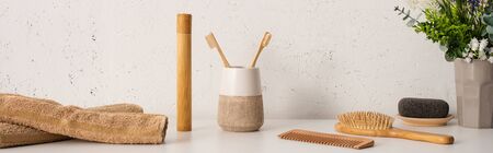Panoramic view of flowerpot, towels and hygiene objects in bathroom, zero waste concept