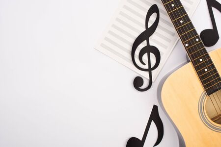 Top view of paper cut notes with music book and acoustic guitar on white backgroundの写真素材