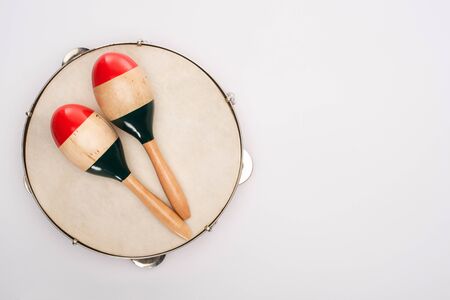 Top view of wooden maracas on tambourine on white backgroundの写真素材