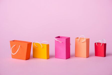colorful and small shopping bags on pink with copy spaceの写真素材