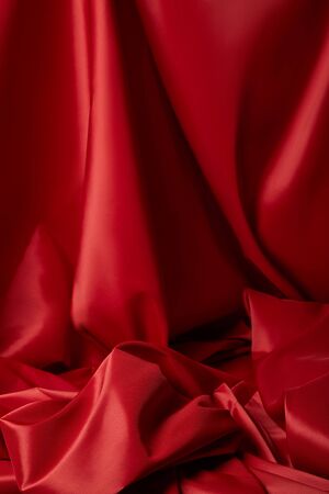 close up view of red soft and crumpled silk textured clothの写真素材