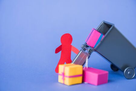 selective focus of paper human near small trash can and presents on blueの写真素材