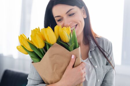 happy woman smiling and looking at tulipsの写真素材