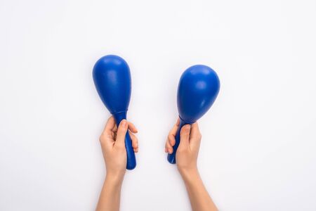 Cropped view of woman holding blue maracas on white backgroundの写真素材