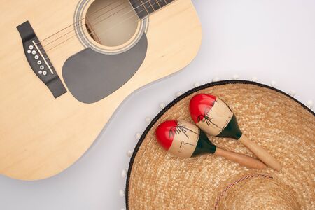 Top view of acoustic guitar with wooden maracas on sombrero on white backgroundの写真素材