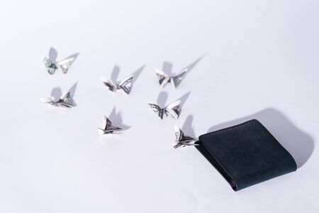 decorative money origami butterflies near wallet on whiteの写真素材