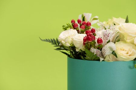 fresh bouquet of flowers in gift box isolated on greenの写真素材