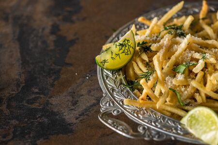 selective focus of salted french fries and sliced lime on marble surfaceの写真素材