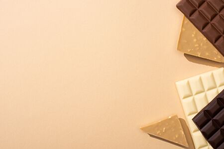 top view of delicious chocolate bars isolated on beige