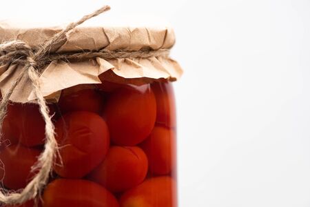 close up view of homemade tasty canned tomatoes in jar isolated on whiteの写真素材