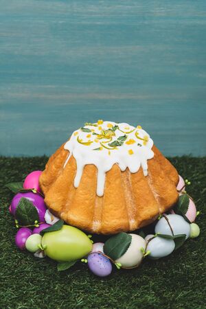 Easter cake in decorative wreath on grass