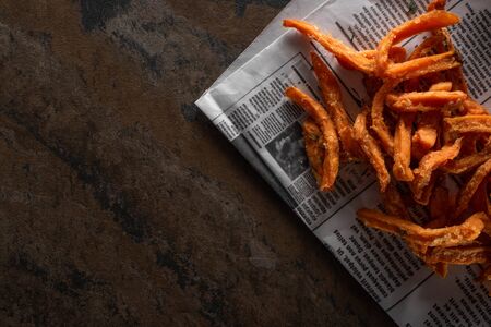 top view of tasty french fries near newspaper on marble surfaceの写真素材