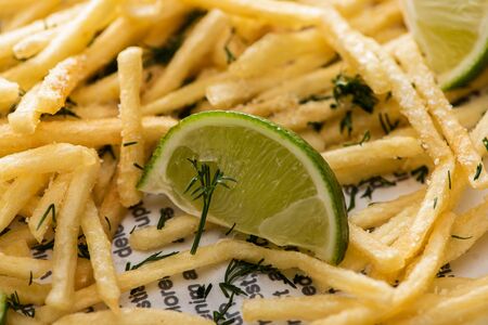 close up of lime near crispy french fries with dillの写真素材
