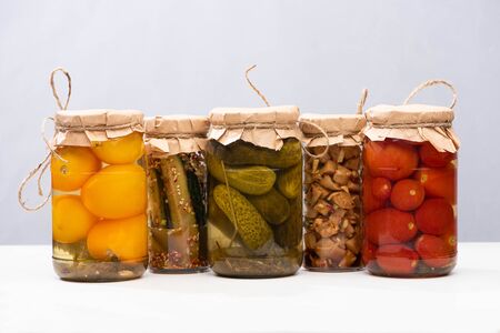 rustic homemade tasty pickles in jars isolated on greyの写真素材