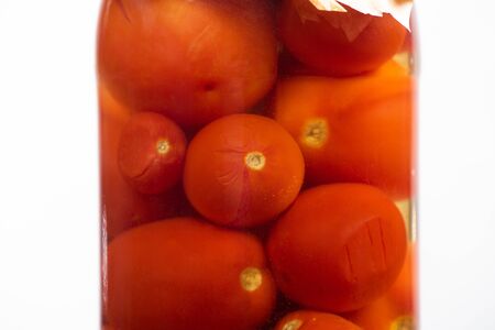 close up view of homemade tasty canned tomatoes in jar isolated on white