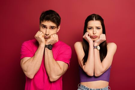 beautiful upset young couple gesturing on red
