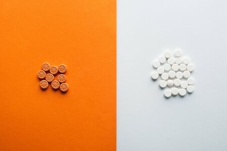 Top view of medicines on white and orange backgroundの写真素材