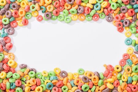 top view of bright multicolored breakfast cereal arranged in frame on white background