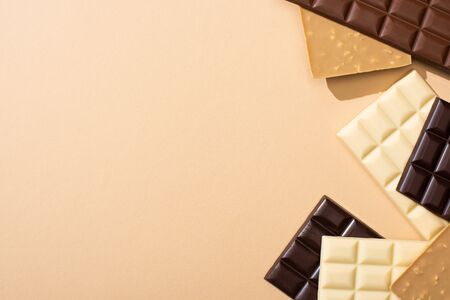 top view of delicious chocolate bars isolated on beigeの写真素材