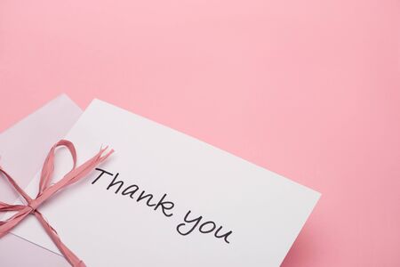 pink bow near thank you greeting card on pink backgroundの写真素材