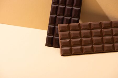 sweet delicious dark, milk chocolate bars on beige backgroundの写真素材
