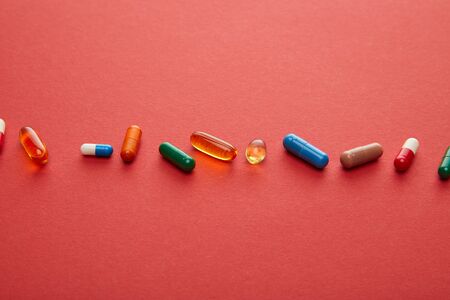 High angle view of pills on red backgroundの写真素材