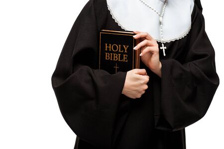 cropped view of nun holding holy bible isolated on white