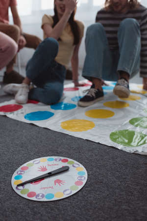 KYIV, UKRAINE - JANUARY 27, 2020: selective focus of moves plate near friends sitting on twister game matのeditorial素材