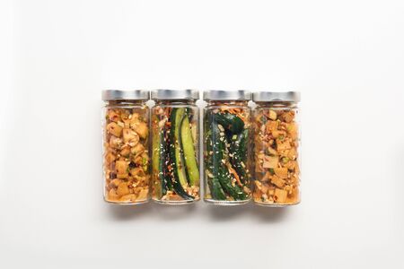 top view of cucumber and daikon radish kimchi in jars on white backgroundの写真素材