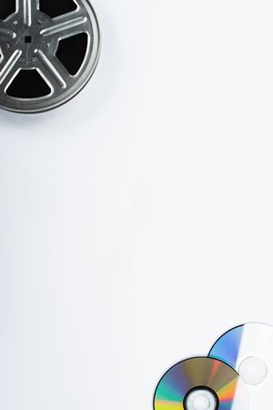 top view of CD discs and film reel on white background