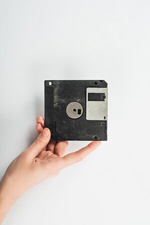 partial view of man holding black diskette on white backgroundの写真素材