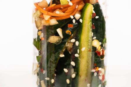 close up of cucumber kimchi in jar isolated on whiteの写真素材