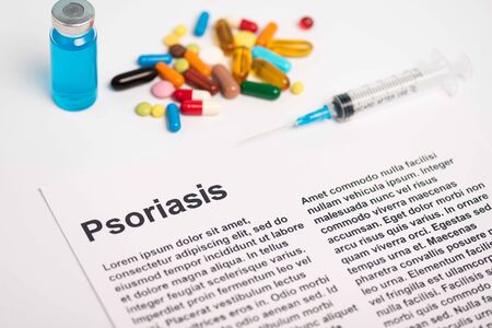 Paper with psoriasis lettering near jar of vaccine, syringe and pills on white backgroundの写真素材