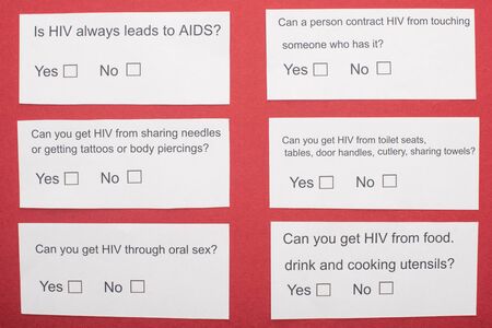 top view of paper cards with HIV questionnaire on red backgroundの写真素材