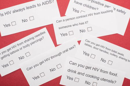 top view of paper cards with HIV questionnaire on red background