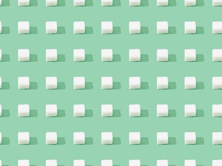 top view of lump sugar on green, seamless background pattern