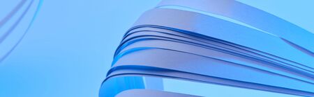 close up view of curved colorful paper stripes on neon blue background, panoramic shotの写真素材