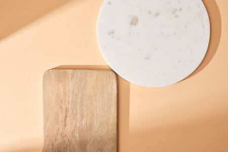 top view of wooden and marble boards on beige backgroundの写真素材